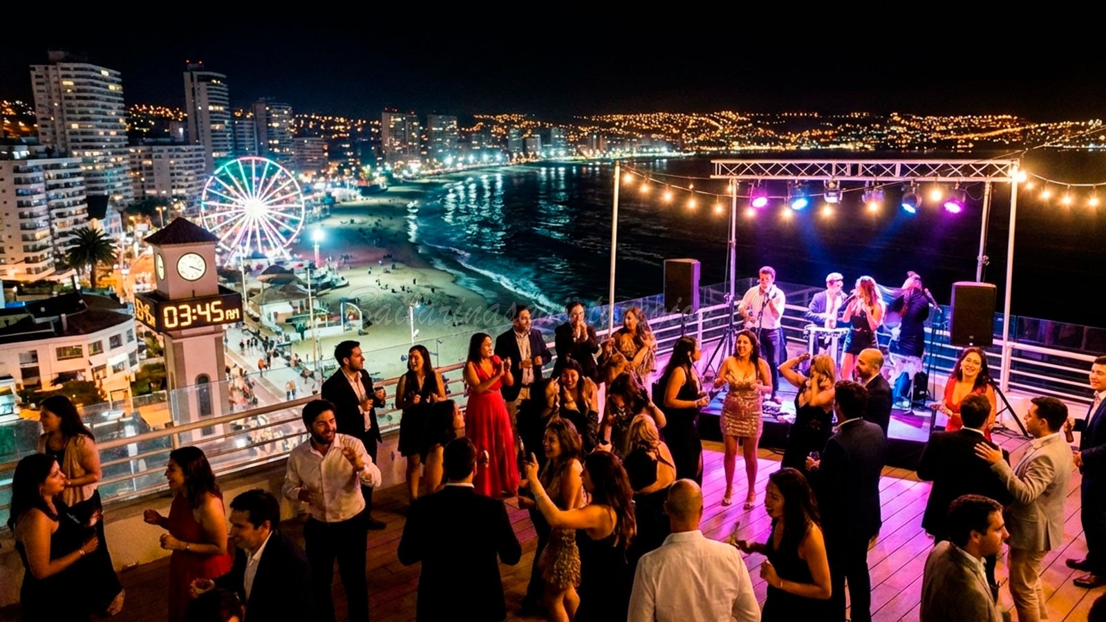 Fiesta nocturna de despedida de soltero en una terraza con vista panorámica a Reñaca y Viña del Mar iluminada.
